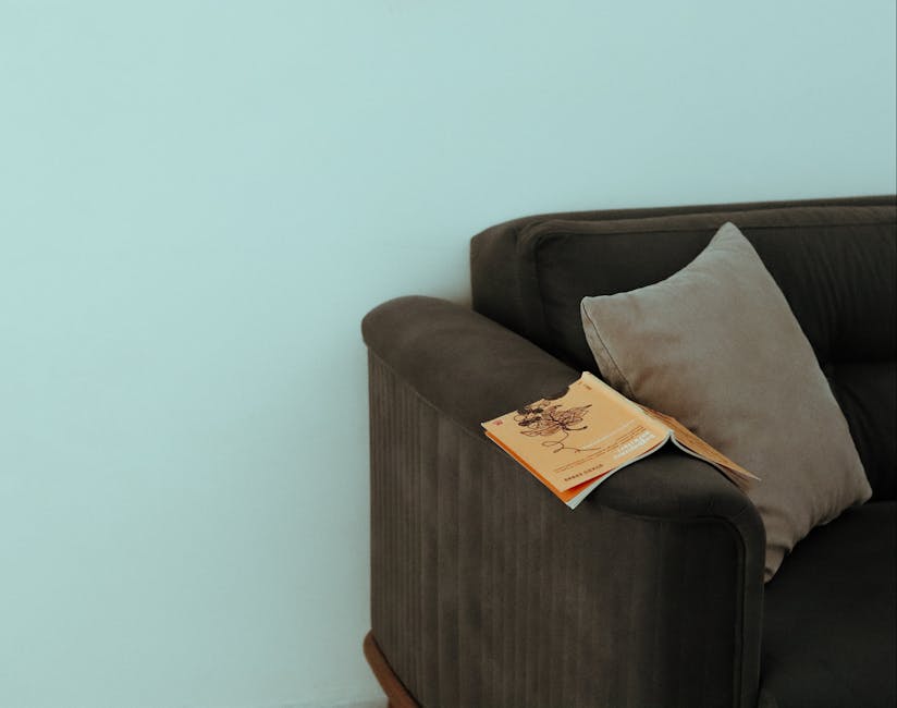 Tranquil corner in a modern living room featuring a book on a couch with a soft cushion.